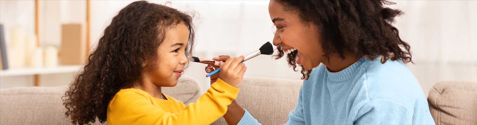 Mother and daughter playing with paint brushes